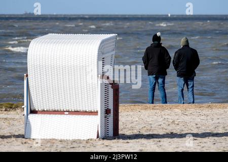 Harlesiel, Deutschland. 09. April 2022. Ein Paar steht bei sonnigem Wetter am Strand und blickt auf die Nordsee. Mit dem Beginn der Ferien in vielen deutschen Bundesländern, darunter Nordrhein-Westfalen, reisten am Samstag viele Osterurlauber an die Küste und die ostfriesischen Inseln. Quelle: Hauke-Christian Dittrich/dpa/Alamy Live News Stockfoto