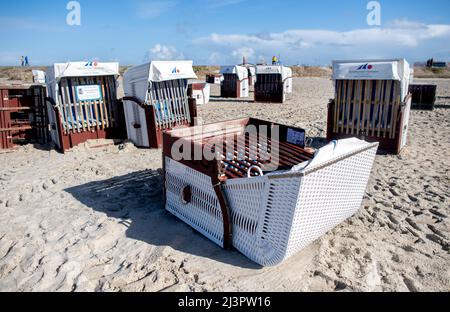 Harlesiel, Deutschland. 09. April 2022. Am Strand liegen gefallene Liegen bei sonnigem, aber auch stürmischem Wetter. Mit dem Beginn der Ferien in vielen deutschen Bundesländern, darunter Nordrhein-Westfalen, reisten am Samstag viele Osterurlauber an die Küste und die ostfriesischen Inseln. Quelle: Hauke-Christian Dittrich/dpa/Alamy Live News Stockfoto