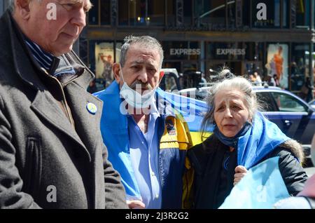 Gealterte Demonstranten, die ukrainische Flagge tragen, um am 09. April 2022 auf dem Times Square in New York City Solidarität mit der Ukraine zu zeigen. Stockfoto