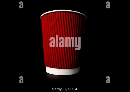 Rote Kaffeetasse aus Papier, isoliert auf Schwarz. Stockfoto