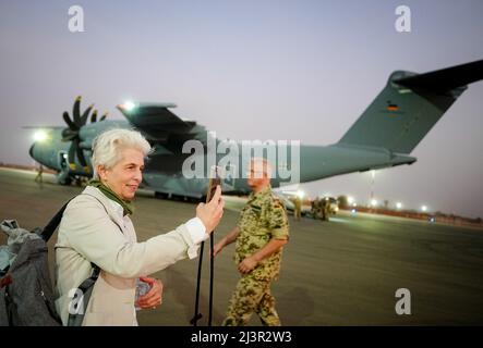 Niamey, Niger. 09. April 2022. Marie-Agnes Strack-Zimmermann (FDP), Vorsitzende des Verteidigungskomitees, macht am Abend ein Foto mit ihrem Smartphone, nachdem sie von Gao in Mali vor dem Air Force Airbus A400M am Flughafen Niamey gelandet ist. Sie begleitet den Verteidigungsminister bei einem Besuch deutscher Soldaten in Westafrika. Die Bundeswehr ist in Niger an der UN-Mission Minusma und der EU-Ausbildungsmission EUTM beteiligt. Quelle: Kay Nietfeld/dpa/Alamy Live News Stockfoto