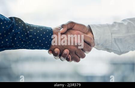 Ich freue mich, Sie an Bord zu haben. Aufnahme von zwei Kollegen, die sich im Büro die Hände schüttelten. Stockfoto