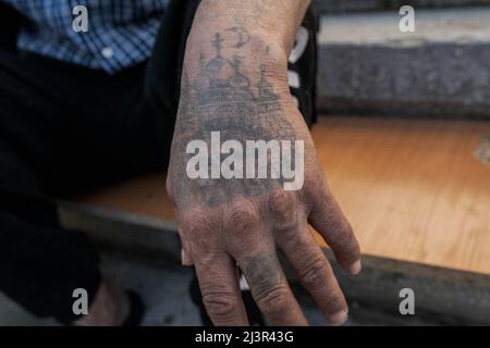 Eine Hand einer Roma-Person mit einem Moskauer Kreml-Tattoo eines der Flüchtlinge. Das Roma-Volk „roma“, auch bekannt als „Zigeuner“, gehört zu den 4 Millionen Menschen, die durch Gewalt aus dem bewaffneten Konflikt in der Ukraine vertrieben wurden und in Flüchtlingshilfezentren in verschiedenen Teilen der Republik Moldau untergebracht sind. Sie sind in der Regel organisiert und von anderen Gruppen getrennt.Es gibt keine genauen Daten, aber nach Angaben von Organisationen wie dem Fundación Secretariado Gitano leben etwa 400.000 Roma in der Ukraine. Stockfoto