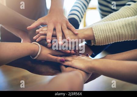 Sie sind nicht in diesem allein. Aufnahme einer Gruppe von nicht identifizierbaren Freunden, die sich solidarisch in die Hände schlossen. Stockfoto