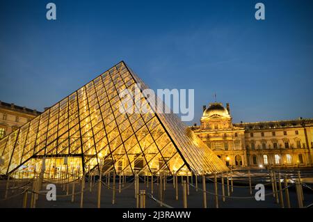 Paris, Frankreich - 18. November 2021: Blick auf das Musée du Louvre mit der Pyramide bei Nacht. Dies ist eines der beliebtesten Reiseziele von Franc Stockfoto
