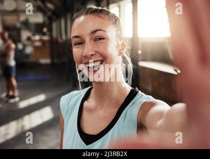 Nehmen Sie das Selfie, Sie wissen nie, wer Sie inspirieren. Aufnahme einer fittenden jungen Frau im Fitnessstudio. Stockfoto