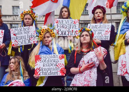 London, England, Großbritannien. 9. April 2022. Demonstranten inszenierten einen massiven "Einmarsch" und hielten "Babys" und Schilder fest, die mit gefälschtem Blut bedeckt waren, um gegen das Massaker in der Stadt Bucha und die Gräueltaten zu protestieren, die angeblich von russischen Truppen in der Ukraine begangen wurden. (Bild: © Vuk Valcic/ZUMA Press Wire) Stockfoto