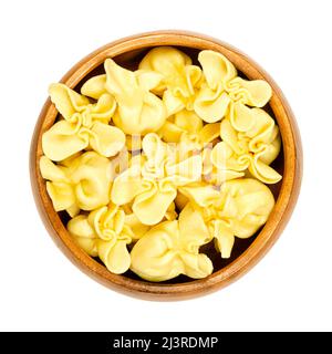 Fagottini, gefüllte italienische Pasta, Knödel in Holzschüssel. Quadratischer Nudelteig, mit Füllung in der Mitte und gefalteten Ecken in einer Spitze. Stockfoto