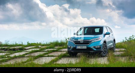 Perechyn, ukraine - 22. JUN 2019: Blauer honda cr-V in den Bergen. wolkiges Wetter im Sommer. Fahrt mit dem Auto Konzept Stockfoto