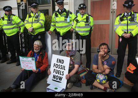 London, Großbritannien. 09. April 2022. Rebellen sitzen vor der Polizeilinie, die während der Demonstration zum Schutz des britischen Hauptquartiers von BP gebildet wurde. Am Eröffnungstag des Extinction Rebellion Spring Rebellion. Die Rebellen haben versprochen, in London Störungen zu verursachen, bis die Regierung ihren Forderungen zuhört und die Klimanotlage erkennt. Kredit: SOPA Images Limited/Alamy Live Nachrichten Stockfoto