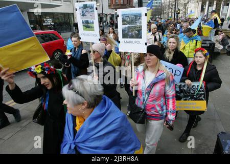 Ukrainische Protesterinnen in Manchester halten Plakate mit Fotoerinnerungen an die Gräueltaten der russischen Armee, die seit der Invasion in Städten in der ganzen Ukraine begangen wurden rund 200 Mitglieder der ukrainischen Gemeinde in Manchester sowie Ukrainer des Kulturzentrums „Dnipro“ marschierten durch das Stadtzentrum. Sie forderten ein Ende der Feindseligkeiten, der Invasion und des Mordes an Zivilisten, die gegen sie verübt wurden, seit Russland im Februar dieses Jahres ohne Provokation in die Ukraine einmarschierte. Viele ukrainische Kinder waren anwesend, als sie plakate hielten, auf denen die von durchgeführten Gräueltaten hervorgehoben wurden Stockfoto