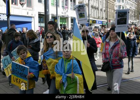 Ukrainische Demonstranten in Manchester marschieren, während sie während der Demonstration Plakate halten. Rund 200 Mitglieder der ukrainischen Gemeinde in Manchester sowie Ukrainer des Kulturzentrums „Dnipro“ marschierten durch das Stadtzentrum. Sie forderten ein Ende der Feindseligkeiten, der Invasion und des Mordes an Zivilisten, die gegen sie verübt wurden, seit Russland im Februar dieses Jahres ohne Provokation in die Ukraine einmarschierte. Viele ukrainische Kinder waren anwesend, als sie plakate hielten, auf denen die Gräueltaten der russischen Armee in Städten wie Bucha und Kramatorsk hervorgehoben wurden. Stockfoto