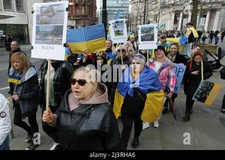 Ukrainische Protesterinnen in Manchester halten Plakate mit Fotoerinnerungen an die Gräueltaten der russischen Armee, die seit der Invasion in Städten in der ganzen Ukraine begangen wurden rund 200 Mitglieder der ukrainischen Gemeinde in Manchester sowie Ukrainer des Kulturzentrums „Dnipro“ marschierten durch das Stadtzentrum. Sie forderten ein Ende der Feindseligkeiten, der Invasion und des Mordes an Zivilisten, die gegen sie verübt wurden, seit Russland im Februar dieses Jahres ohne Provokation in die Ukraine einmarschierte. Viele ukrainische Kinder waren anwesend, als sie plakate hielten, auf denen die von durchgeführten Gräueltaten hervorgehoben wurden Stockfoto