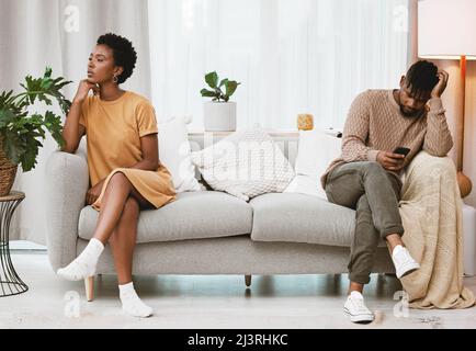 Hes immer am Telefon. Aufnahme eines jungen Paares, das zu Hause einen Streit geführt hat. Stockfoto