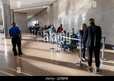 SeaTac, Washington, USA. 9.. April 2022. Ein TSA-Agent überwacht Freiwillige, die während einer Passagierflussimulation in der Internationalen Ankunftshalle am Seattle-Tacoma International Airport zur Sicherheitsüberprüfung aufsteigen. Die neue 450.000 Quadratmeter große Anlage des Hafens von Seattle wird voraussichtlich nächsten Monat nach Abschluss der endgültigen Betriebsbereitschaftstests eröffnet. Quelle: Paul Christian Gordon/Alamy Live News Stockfoto