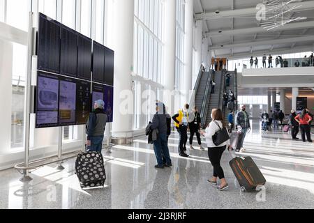 SeaTac, Washington, USA. 9.. April 2022. Freiwillige überprüfen das Anzeigesystem für Fluginformationen während einer Passagier-Flow-Simulation in der Internationalen Ankunftshalle am Seattle-Tacoma International Airport. Die neue 450.000 Quadratmeter große Anlage des Hafens von Seattle wird voraussichtlich nächsten Monat nach Abschluss der endgültigen Betriebsbereitschaftstests eröffnet. Quelle: Paul Christian Gordon/Alamy Live News Stockfoto