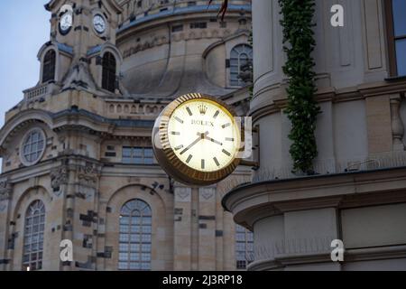 Riesige Rolex Luxusuhr auf einer Gebäudeaußenfassade, die die Zeit anzeigt. Beleuchtete Uhr an der Fassade eines Geschäfts. Einkaufsmöglichkeiten vor der Frauenkirche. Stockfoto