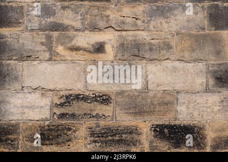 Massive Steinmauer aus Sandsteinblöcken. Gebäude außen eines alten Hauses in Dresden. Grau gefärbte Materialien als Hintergrundstruktur. Stockfoto