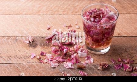 Prozess der Herstellung von Zwiebelschälendünger, Zwiebelhaut in Wasser mit verstreuten Stücken getränkt, Lebensmittelabfälle als natürlicher Dünger, Küche und Haushalt verwendet Stockfoto