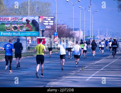 Rückansicht einer Gruppe von Leuten, die einen Straßenmarathon laufen Stockfoto