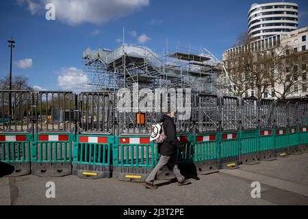 London, Großbritannien. 09. April 2022. Ein Fußgänger geht am absteigenden Marble Arch Mound vorbei. Der Marble Arch Mound, der £6 Millionen gebaut werden muss, wird nach großer Enttäuschung und weitverbreitetem Spott in den sozialen Medien demontiert. (Foto von Hesther Ng/SOPA Images/Sipa USA) Quelle: SIPA USA/Alamy Live News Stockfoto