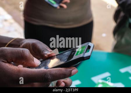 Nairobi, Kenia. 09. April 2022. Während der neuen SIM-Kartenregistrierung außerhalb des Safaricom-Kundendienstes (einem der führenden Mobilfunkanbieter in Kenia) hilft ein Kundenbetreuungsspezialist bei der Betreuung von Services. Die Communications Authority (CA) in Kenia warnte Mobilfunkteilnehmer, die ihre Daten bis April 15 nicht bei ihren jeweiligen Telekommunikationsanbietern registrieren, vor einer Trennung der Verbindung. Kredit: SOPA Images Limited/Alamy Live Nachrichten Stockfoto