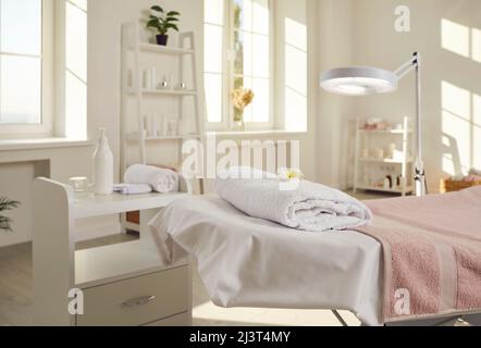 Kosmetikstudio, Spa-Salon oder Massageraum mit Bett, Vergrößerungslampe und Hautpflegeprodukten Stockfoto