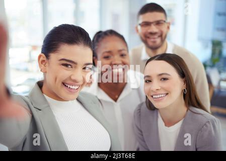 Wenn Sie zusammen lachen können, können Sie zusammenarbeiten. Aufnahme einer Gruppe von Kollegen, die ein Selfie machen. Stockfoto