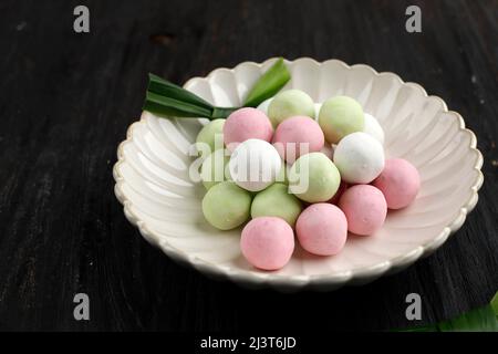 Rohe rote, weiße und grüne Tangyuan-Kumpelbälle auf Holztisch-Hintergrund für das Winteressen am Solstice Festival. Stockfoto