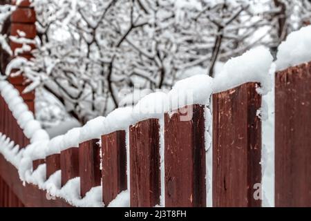 Ländliche Holzzaun bedeckt mit frisch gefallenen Schnee. Stockfoto