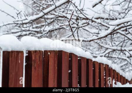 Ländliche Holzzaun bedeckt mit frisch gefallenen Schnee. Stockfoto