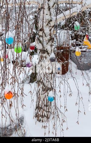 Schneebedeckte Wollornamente hängen aus nächster Nähe an den Ästen. Stockfoto