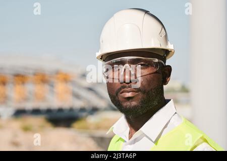 Porträt eines jungen männlichen Ingenieurs, der auf der Baustelle posiert Stockfoto