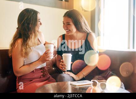 Es ist zu lange her. Eine kurze Aufnahme von zwei attraktiven jungen Frauen, die in ihrem lokalen Café chillen. Stockfoto