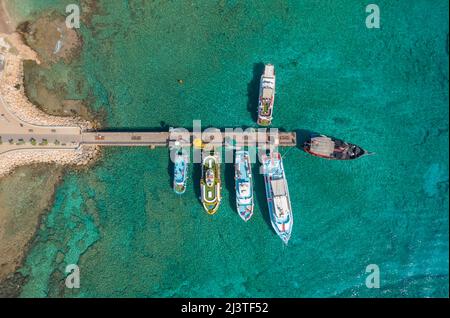 Mehrfarbige Vergnügungsschiffe, die am Pier festgemacht sind, Blick von oben, aus der Luft Stockfoto