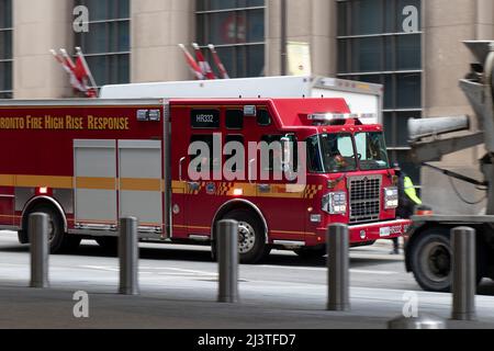Ein Toronto Fire Truck reagiert auf einen Anruf und eilt durch die geschäftige Straße in der Innenstadt von Toronto. Stockfoto