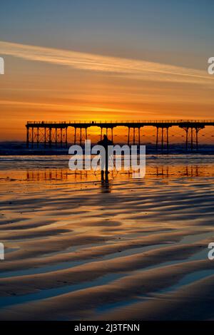 Saltburn-by-the-Sea, Großbritannien. 10 April 2022. Der klare Himmel und die niedrigen Temperaturen über Nacht führten zu einem atemberaubenden Sonnenaufgang in Saltburn-by-the-Sea an der Küste von North Yorkshire. Fotografen und Hundespaziergänger genossen das Spektakel. Quelle: Teesside Snapper/Alamy Live News. Stockfoto