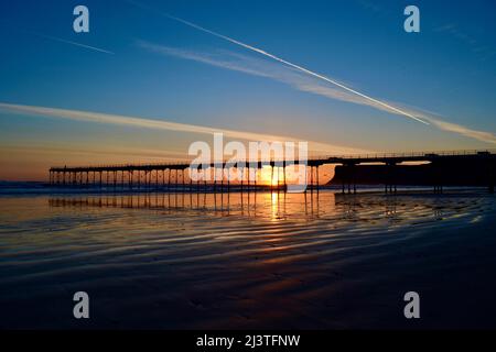 Saltburn-by-the-Sea, Großbritannien. 10 April 2022. Der klare Himmel und die niedrigen Temperaturen über Nacht führten zu einem atemberaubenden Sonnenaufgang in Saltburn-by-the-Sea an der Küste von North Yorkshire. Fotografen und Hundespaziergänger genossen das Spektakel. Quelle: Teesside Snapper/Alamy Live News. Stockfoto