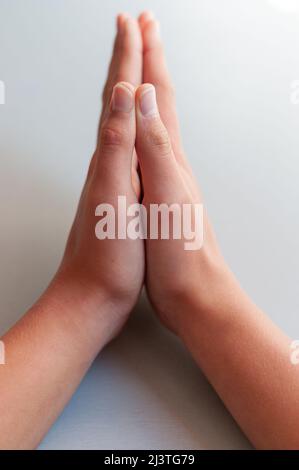 Betende Hände auf einem hellgrauen Hintergrund, Konzept des Glaubens und des Glaubens. Stockfoto
