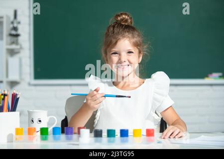 Mädchen in der Schule zeichnet mit Farben. Kinder Künstler Kreativität. Lustige Kinder Emotionen. Stockfoto