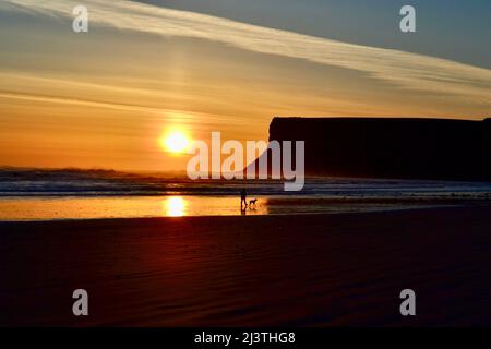 Atemberaubende Aufnahme eines wunderschönen Sonnenaufgangs in Saltburn-by-the-Sea an der Küste von North Yorkshire, Großbritannien. Auch ein Hundespaziergänger am frühen Morgen genießt die Szene. Stockfoto