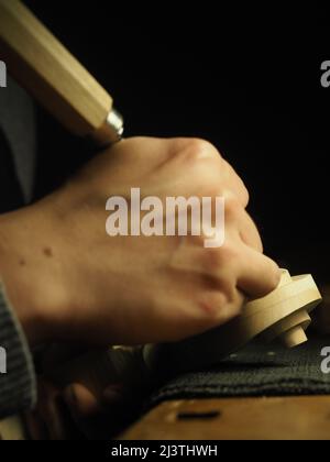 Handwerkliche Bildhauerei einer Geigenrolle - Konzept des Geigenbauers bei der Arbeit Stockfoto