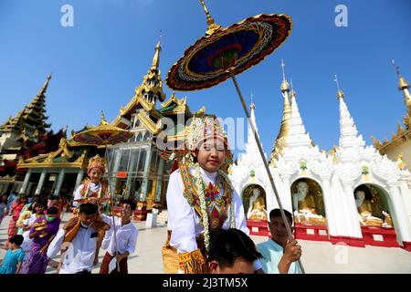 Yangon, Myanmar. 10. April 2022. Jungen in traditioneller Kleidung nehmen an der Shinbyu Noviziationszeremonie in der Shwedagon Pagode in Yangon, Myanmar, am 10. April 2022 Teil. Die Noviziationszeremonie von Shinbyu ist ein wesentlicher Bestandteil im Leben eines männlichen Buddhisten unter 20 Jahren in Myanmar. Quelle: U Aung/Xinhua/Alamy Live News Stockfoto