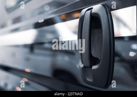 Nahaufnahme des Griffs der schwarzen seitlichen Schiebetür des Fahrzeugs Stockfoto