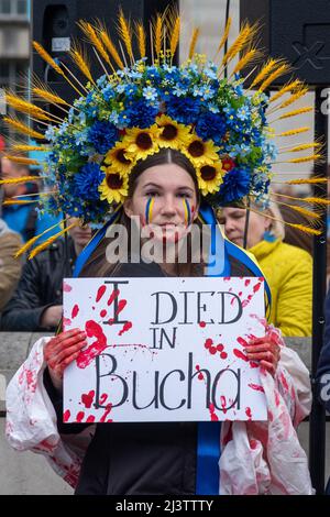 London, Großbritannien. 9. April 2022. Hunderte von Ukrainern simulieren ihren Tod bei einem Todesfall mit gefesselten Händen hinter ihrem Rücken und Frauen malen Blut auf ihre Gesichter, um gegen die andauernde russische Invasion der Ukraine gegenüber der Downing Street zu protestieren. Stockfoto