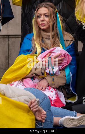 Demonstranten, die einen Einfall verübt haben, verweisen auf die getöteten ukrainischen Zivilisten in Städten wie Bucha während des Krieges mit Russland. „Mutter“ mit „totes Baby“ Stockfoto