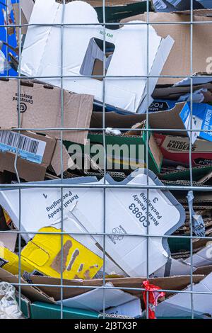 10. April 2022. Recycelbare Kartons in Rollkäfigen oder Drahtwagen vor dem Supermarkt, die darauf warten, für das Recycling abgeholt zu werden, London Stockfoto