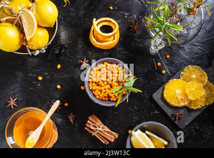 Zutaten für den Immun Booster Sanddorntee: Beeren, Orangen, Zitrone, Zimt, Anissterne und Honig Stockfoto