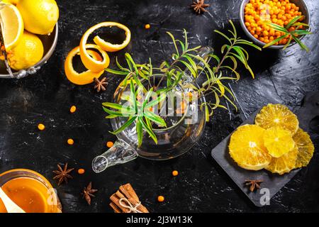 Gesunde Sanddorntee-Zutaten: Beeren, Orange, Zitrone, Zimt, Anissterne und Honig Stockfoto