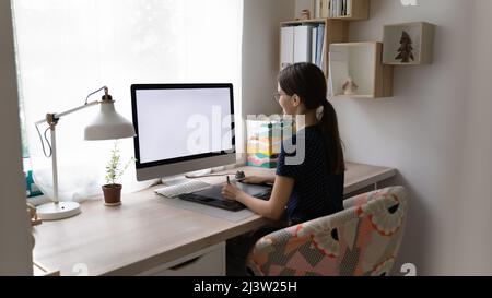 Frau, die am pc arbeitet, hält einen digitalen Grafiktablett Stockfoto